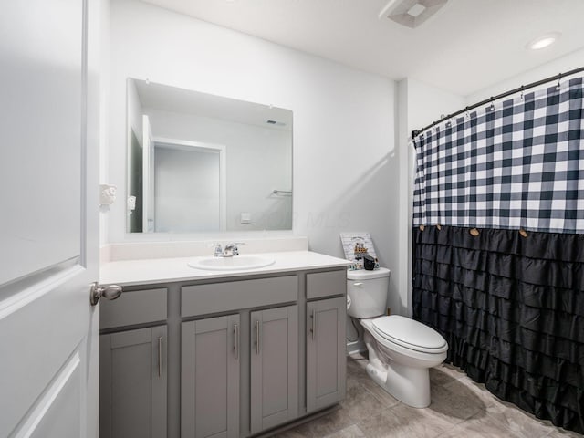 bathroom with toilet, vanity, and walk in shower