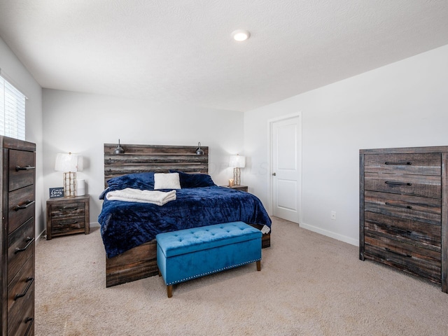 bedroom featuring light carpet and a textured ceiling