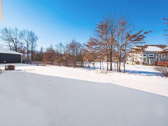 yard layered in snow featuring central air condition unit