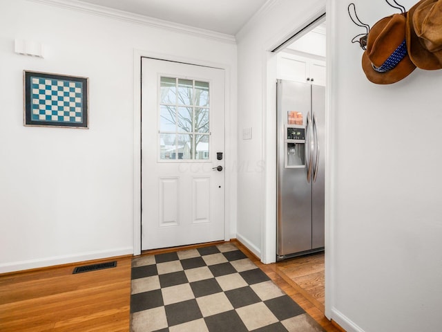 entryway with dark hardwood / wood-style flooring and crown molding