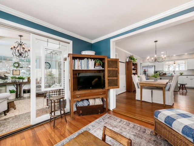 living room with hardwood / wood-style floors, crown molding, and a notable chandelier