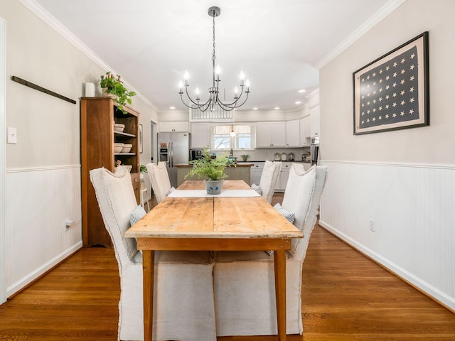 unfurnished dining area featuring hardwood / wood-style flooring, ornamental molding, and a chandelier