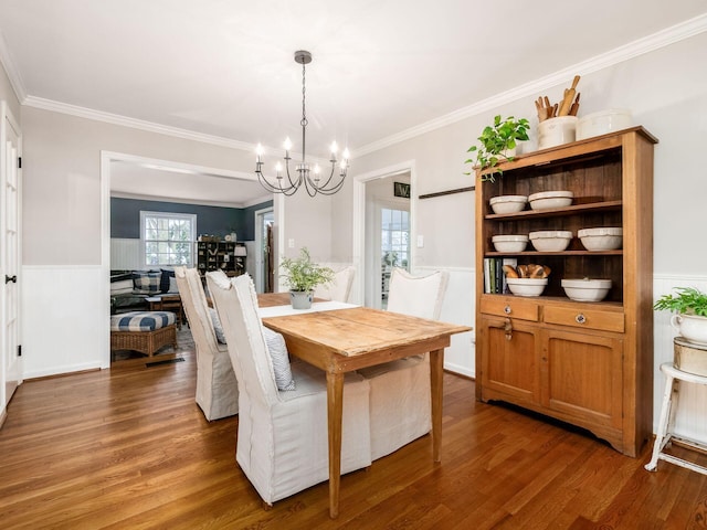 dining room featuring dark hardwood / wood-style flooring, crown molding, and a chandelier