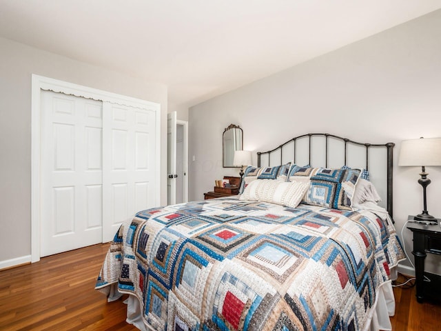 bedroom with dark hardwood / wood-style flooring and a closet