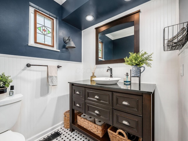 bathroom featuring tile patterned flooring, vanity, toilet, and crown molding