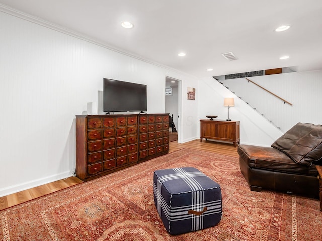 living room featuring hardwood / wood-style flooring and crown molding