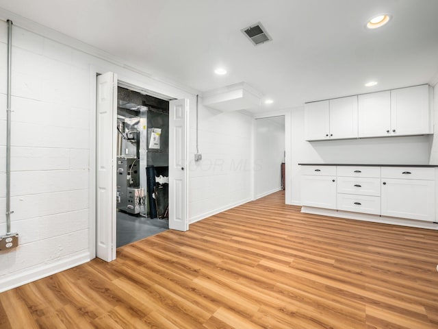 interior space with light hardwood / wood-style flooring and ornamental molding