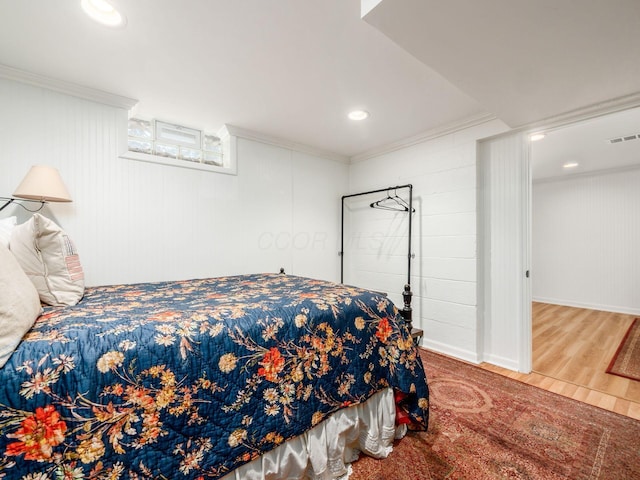 bedroom with hardwood / wood-style floors and ornamental molding