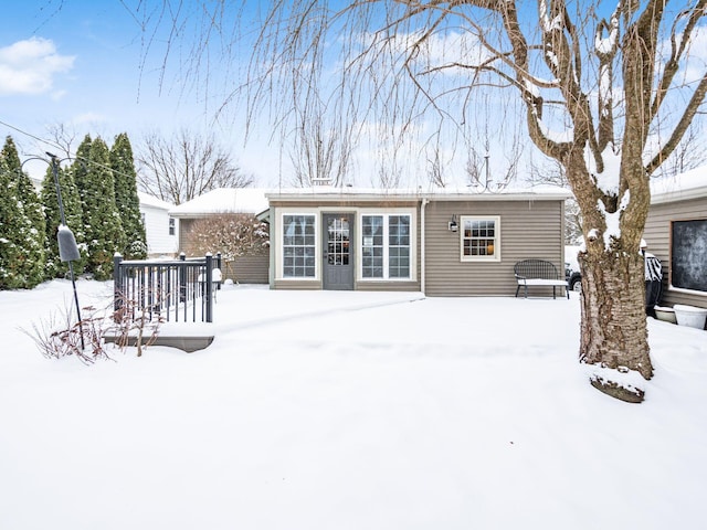 snow covered property with a deck