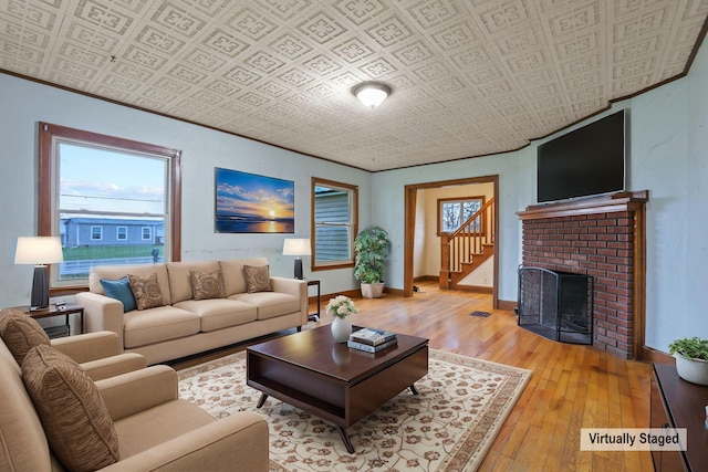 living room featuring light wood-type flooring and a brick fireplace