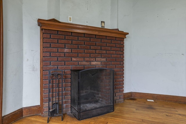 room details featuring hardwood / wood-style flooring and a brick fireplace