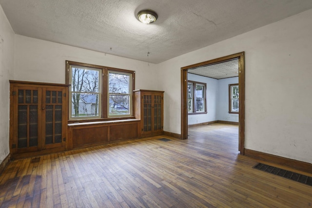 empty room featuring wood-type flooring and a textured ceiling