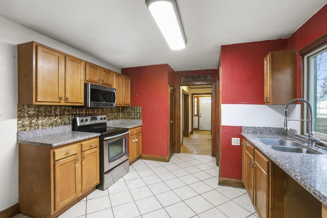 kitchen featuring decorative backsplash, sink, light tile patterned floors, and stainless steel appliances