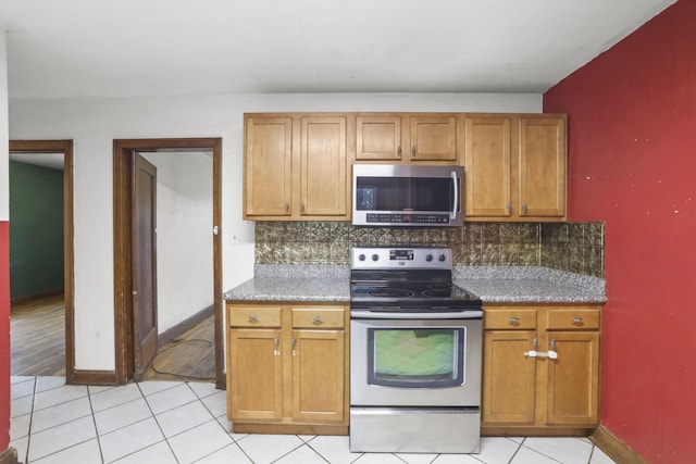 kitchen featuring tasteful backsplash, light tile patterned flooring, and stainless steel appliances