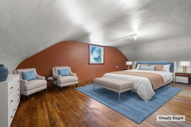 bedroom with hardwood / wood-style flooring and lofted ceiling