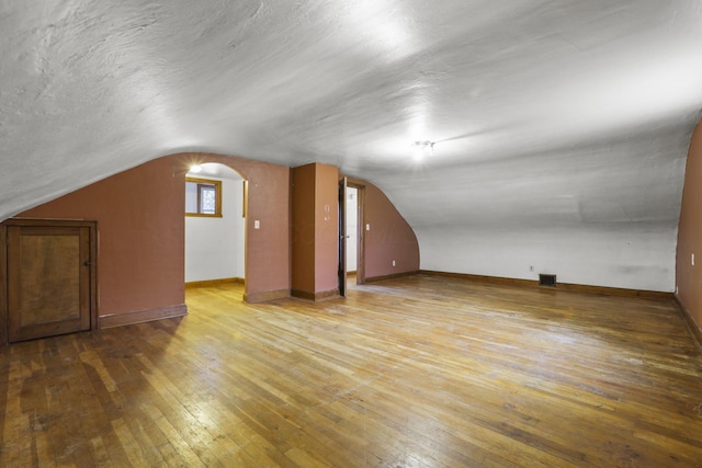 bonus room featuring hardwood / wood-style flooring and vaulted ceiling