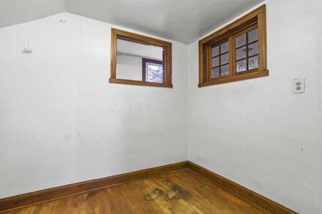 empty room featuring lofted ceiling and dark wood-type flooring