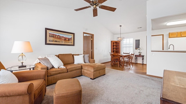 carpeted living room with ceiling fan and lofted ceiling