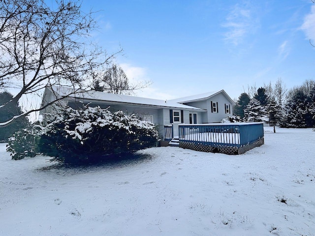 snow covered house featuring a wooden deck