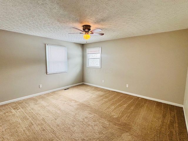 empty room with visible vents, baseboards, light colored carpet, and a ceiling fan