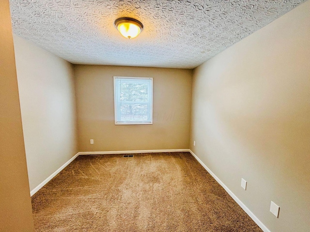 unfurnished room featuring baseboards, carpet floors, and a textured ceiling