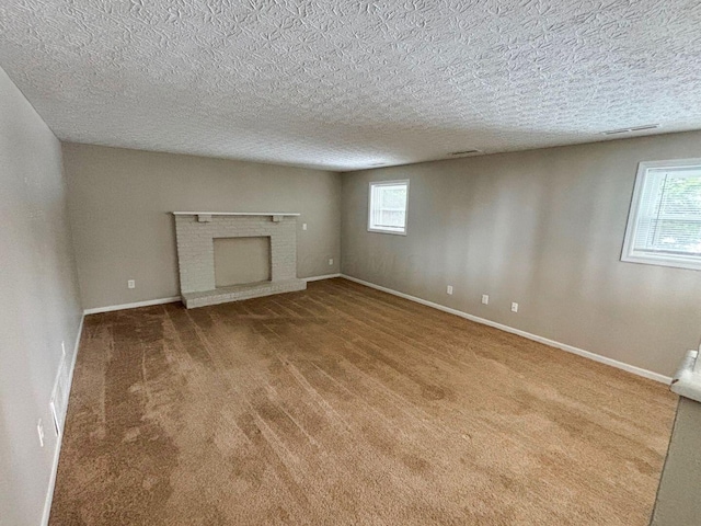 unfurnished living room featuring visible vents, a fireplace, baseboards, and carpet