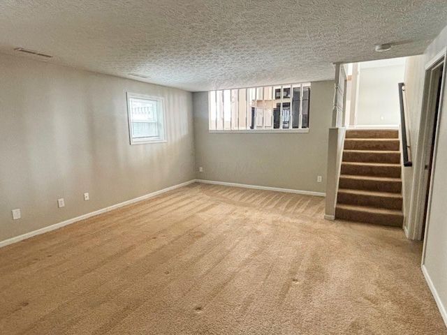 interior space with stairway, baseboards, and a textured ceiling