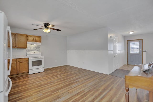 kitchen featuring white appliances, tasteful backsplash, ceiling fan, and light hardwood / wood-style floors