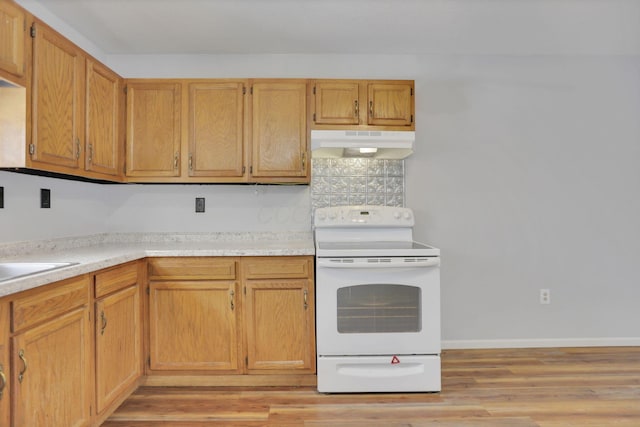 kitchen featuring decorative backsplash, light hardwood / wood-style floors, white range with electric cooktop, and sink