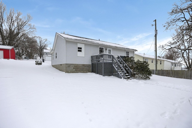 snow covered house with a wooden deck