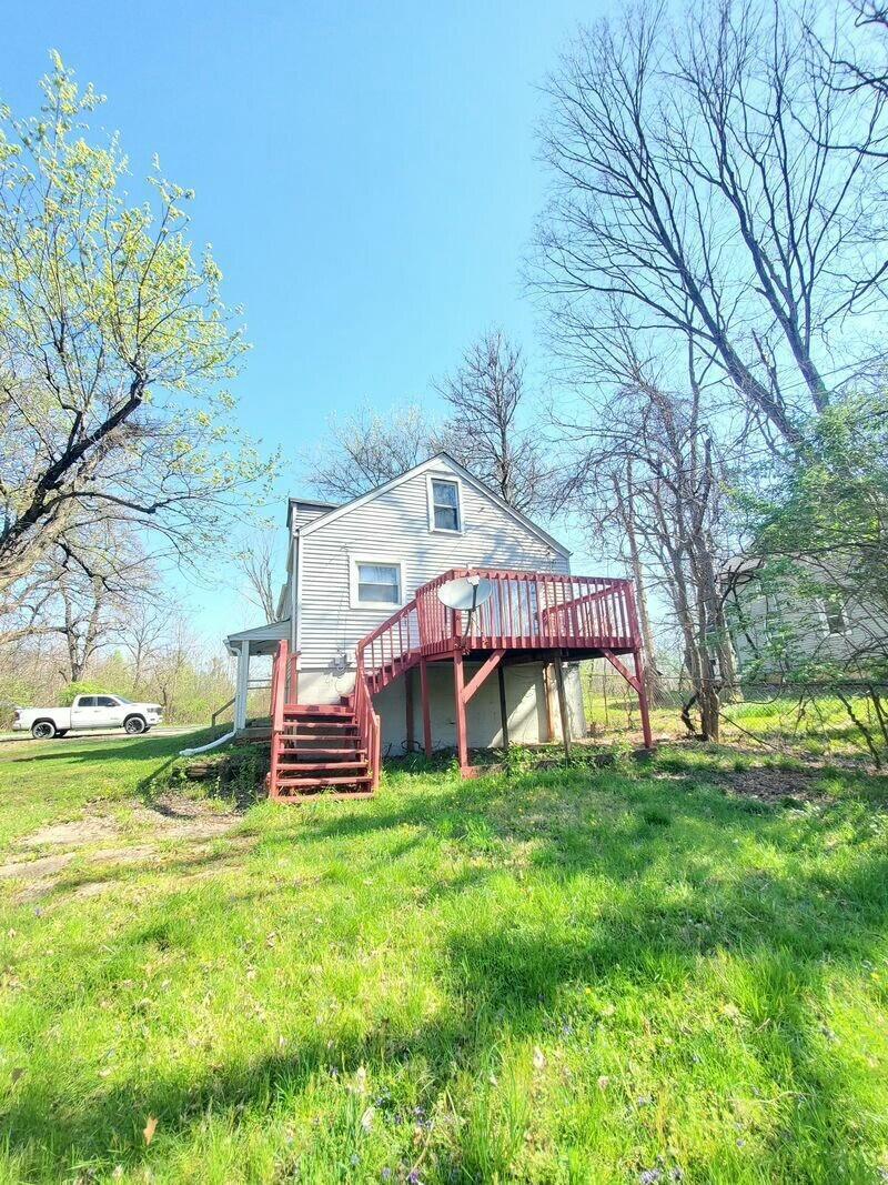 back of property featuring a yard and a deck