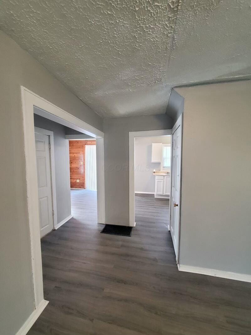 corridor featuring dark hardwood / wood-style floors and a textured ceiling