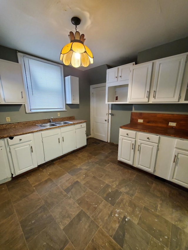 kitchen featuring white cabinetry and sink