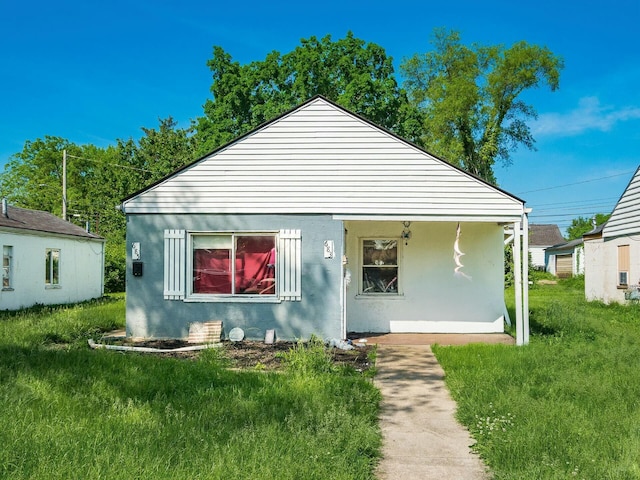 rear view of house with a lawn and covered porch