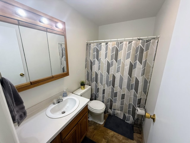 bathroom featuring vanity, toilet, and walk in shower