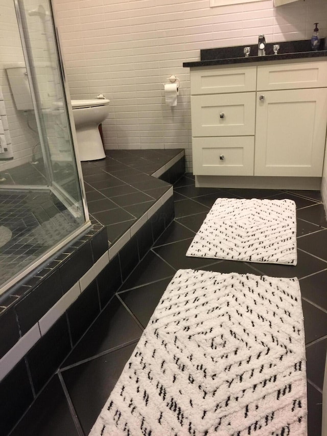 bathroom with an enclosed shower, tile patterned floors, and toilet