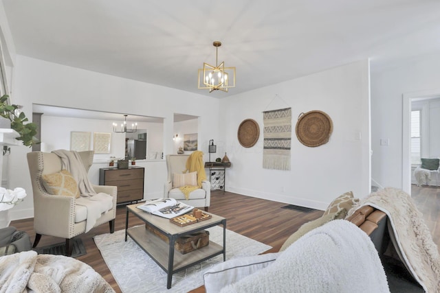 living room with dark wood-type flooring and a notable chandelier