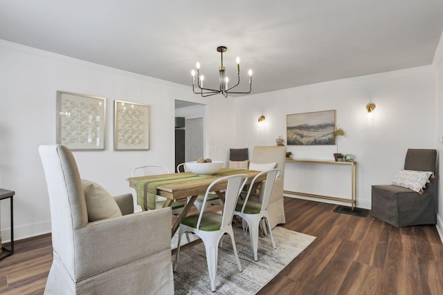 dining area with a chandelier, crown molding, and dark wood-type flooring