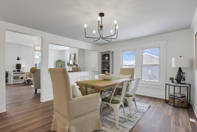 dining space featuring crown molding, a chandelier, and dark hardwood / wood-style floors