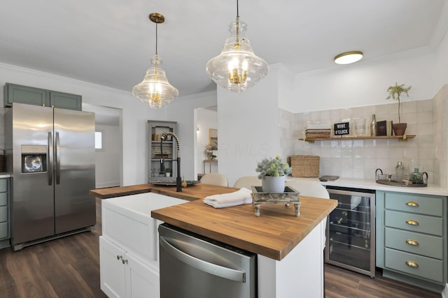 kitchen featuring wood counters, appliances with stainless steel finishes, beverage cooler, sink, and a kitchen island