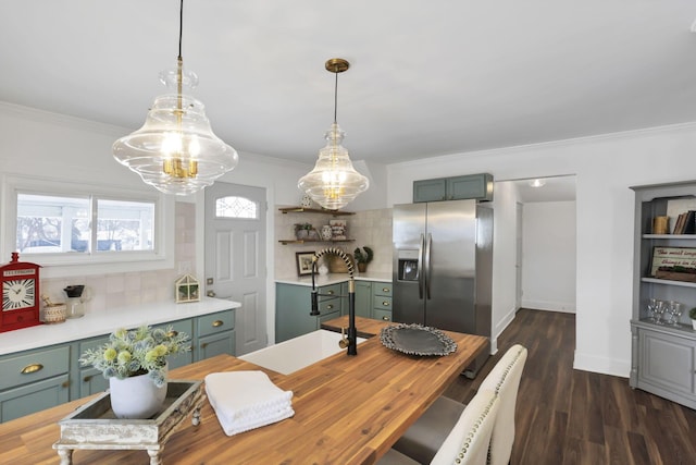 kitchen featuring decorative backsplash, stainless steel fridge, dark hardwood / wood-style floors, ornamental molding, and decorative light fixtures