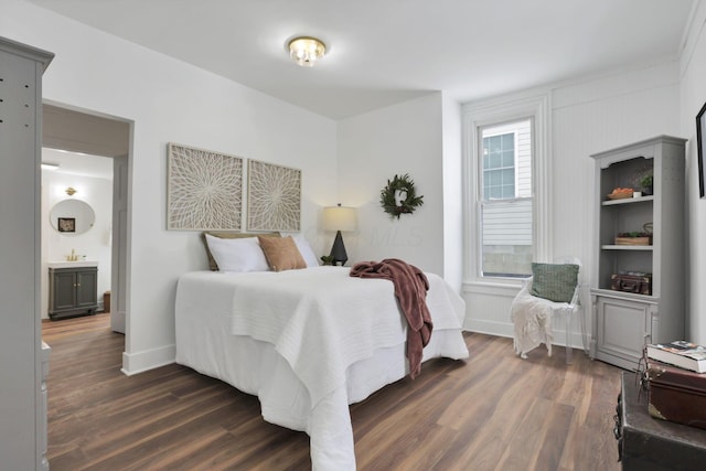 bedroom with ensuite bath and dark hardwood / wood-style flooring