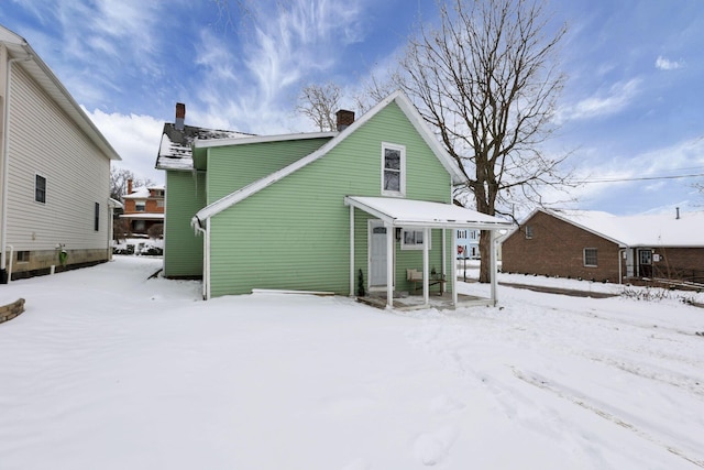 view of snow covered rear of property