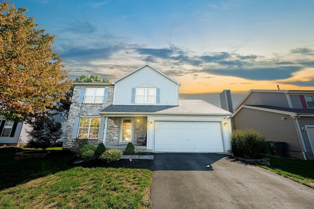 front of property with a garage and a lawn