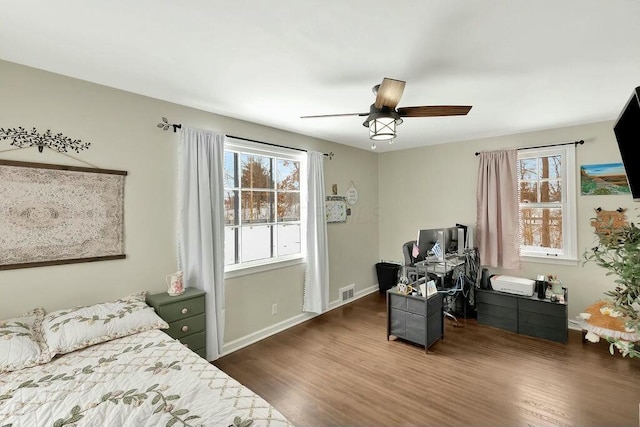 bedroom with dark wood-type flooring, ceiling fan, and multiple windows