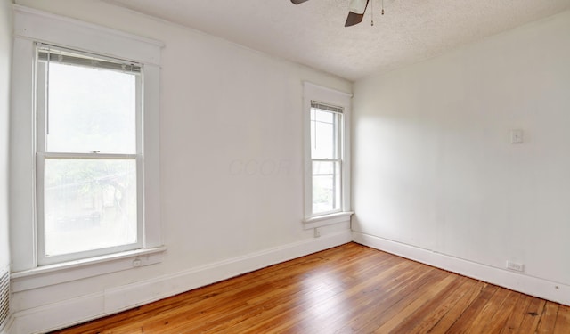 spare room with a textured ceiling, hardwood / wood-style flooring, and ceiling fan