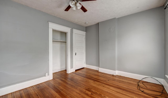 unfurnished bedroom with hardwood / wood-style flooring, ceiling fan, a textured ceiling, and a closet