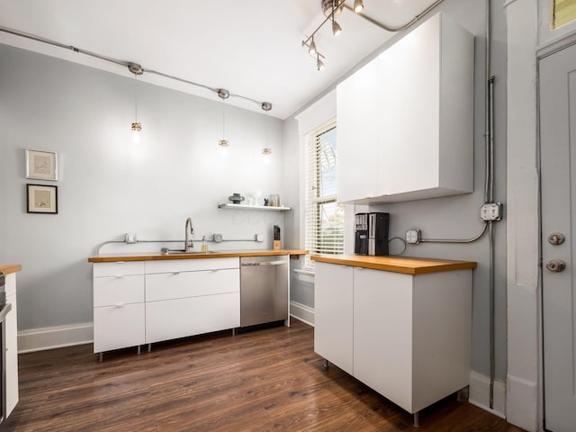 kitchen featuring white cabinetry, sink, stainless steel dishwasher, butcher block countertops, and pendant lighting