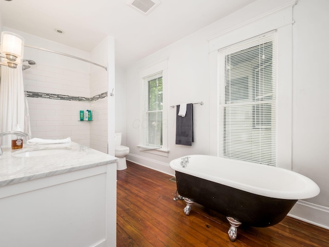 bathroom featuring wood-type flooring, vanity, toilet, and a bathing tub