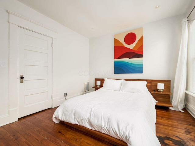 bedroom with dark wood-type flooring